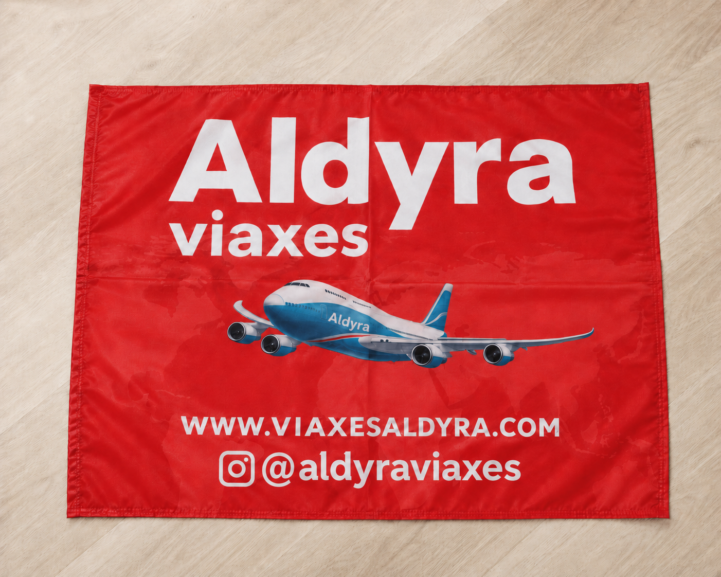 Bandera promocional Aldyra Viaxes Bandera promocional roja de Aldyra Viaxes con avión, web viaxesaldyra.com e Instagram @aldyraviaxes.